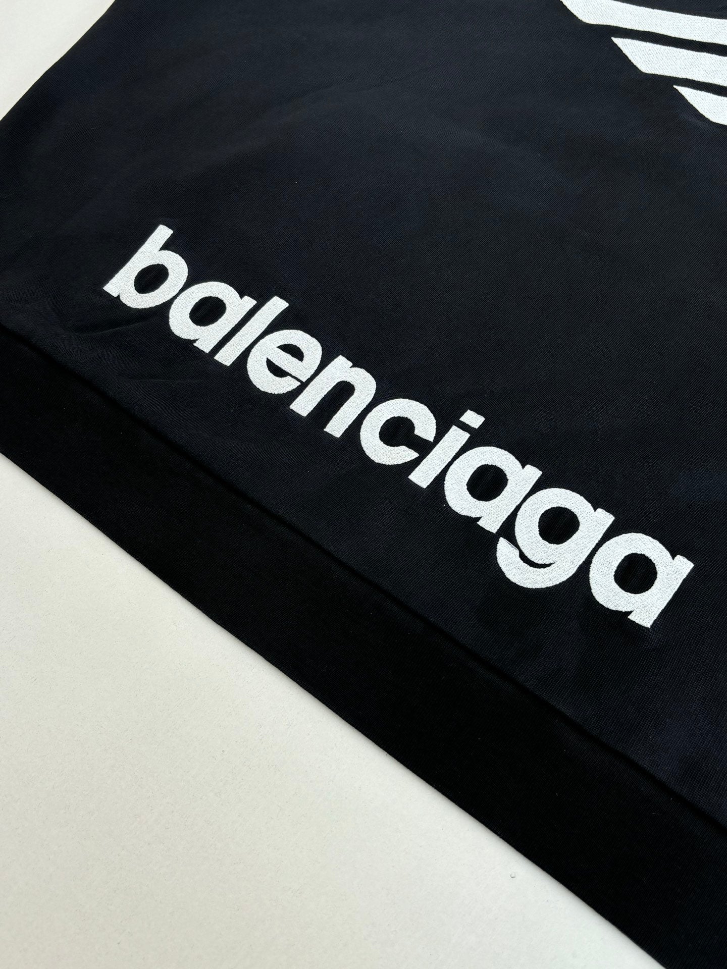 Balenciaga top with white 'balenciaga' logo lettering on black sleeve