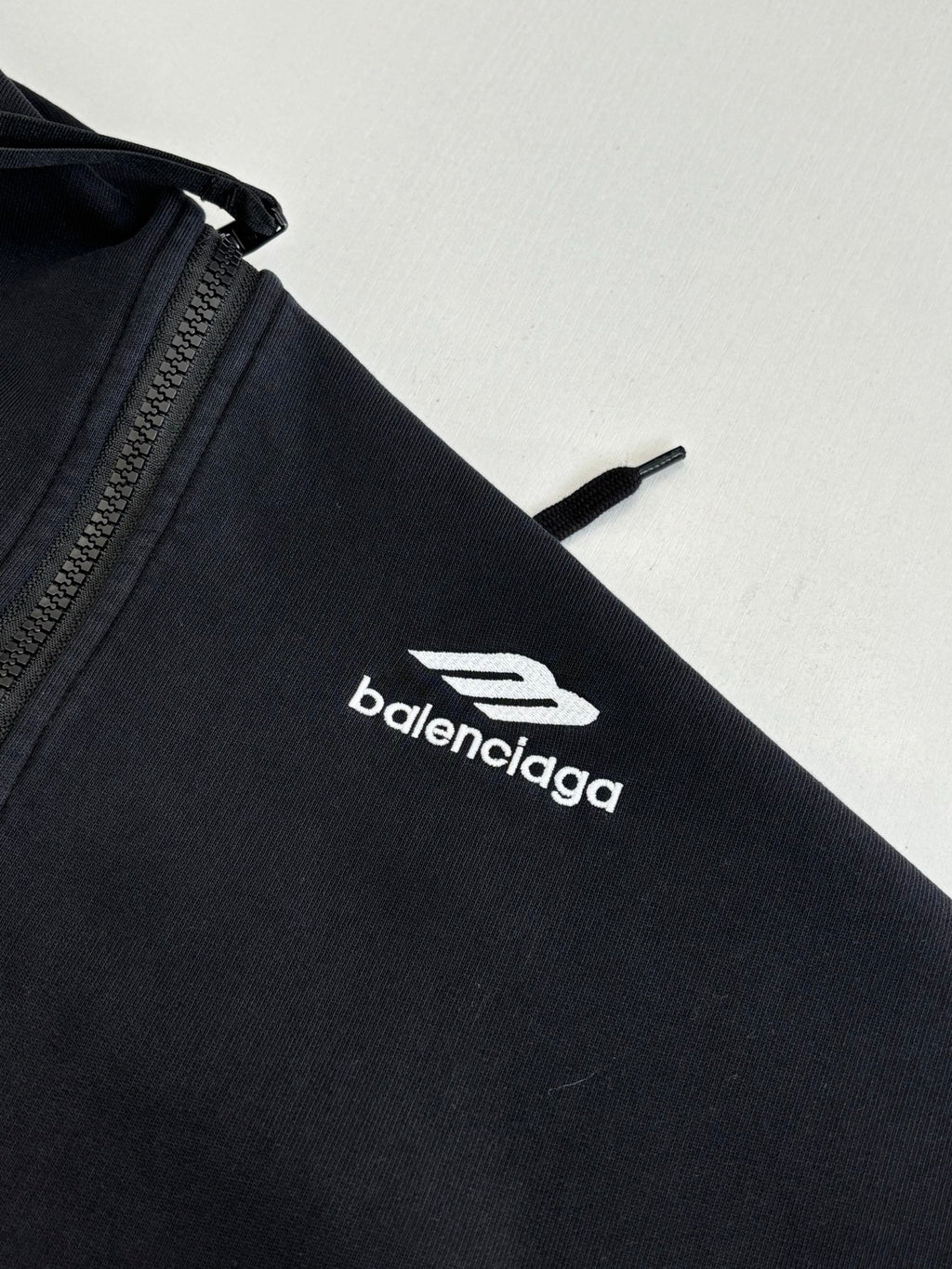 Balenciaga black hoodie sleeve with white balenciaga logo emblem