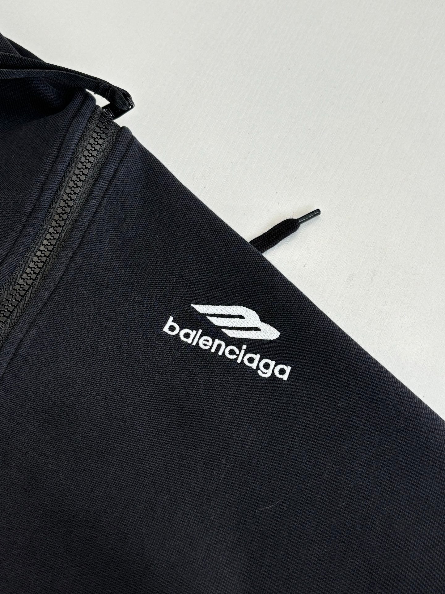 Balenciaga black hoodie sleeve with white balenciaga logo emblem