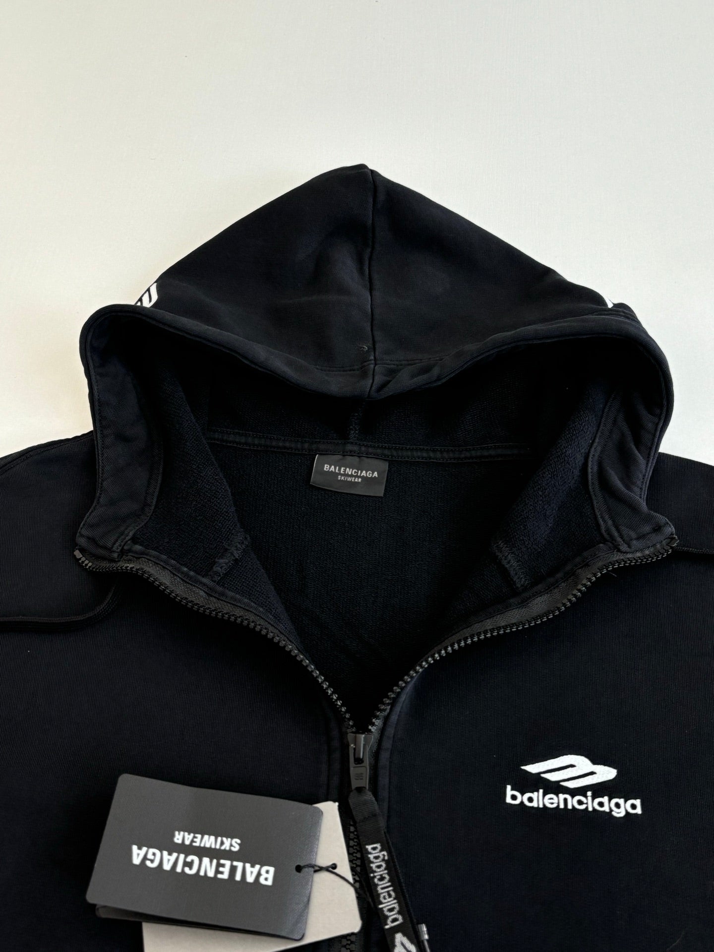Balenciaga black hoodie close-up of hood, front zip, and neck label