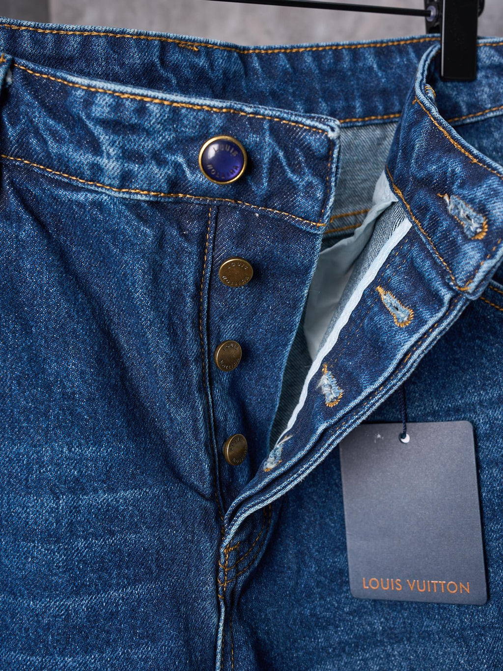 Louis Vuitton blue denim pants close-up of button fly, coin pocket, and tags