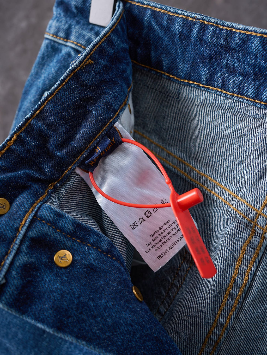 Louis Vuitton blue denim pants close-up of pocket edge and red security tag