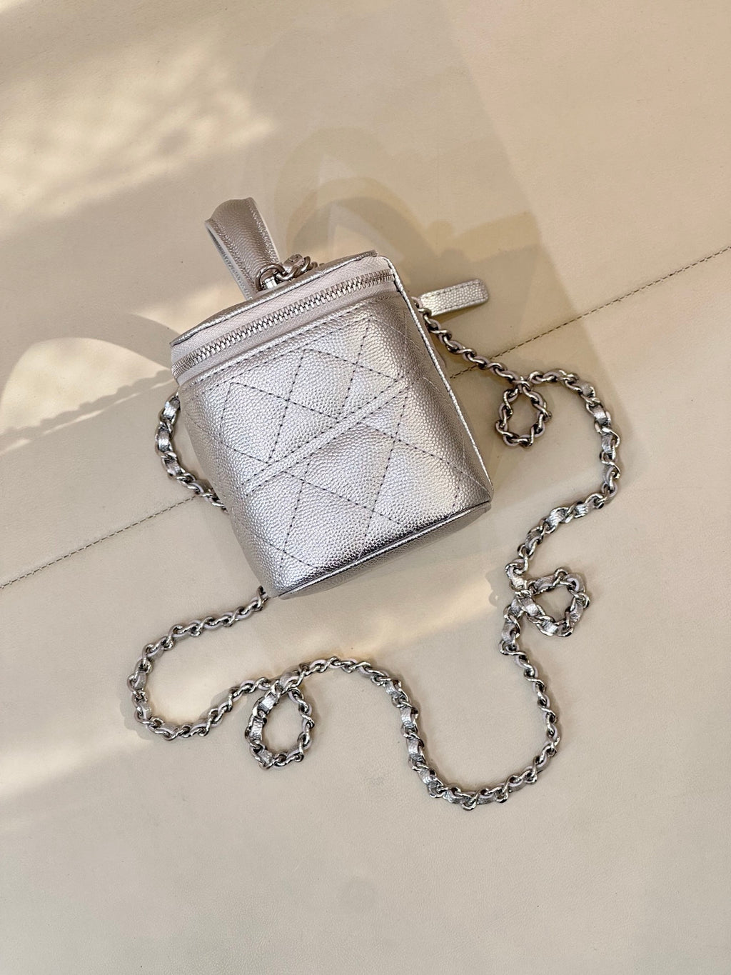 Mini quilted handbag with top handle and silver-tone shoulder chain, front flap logo