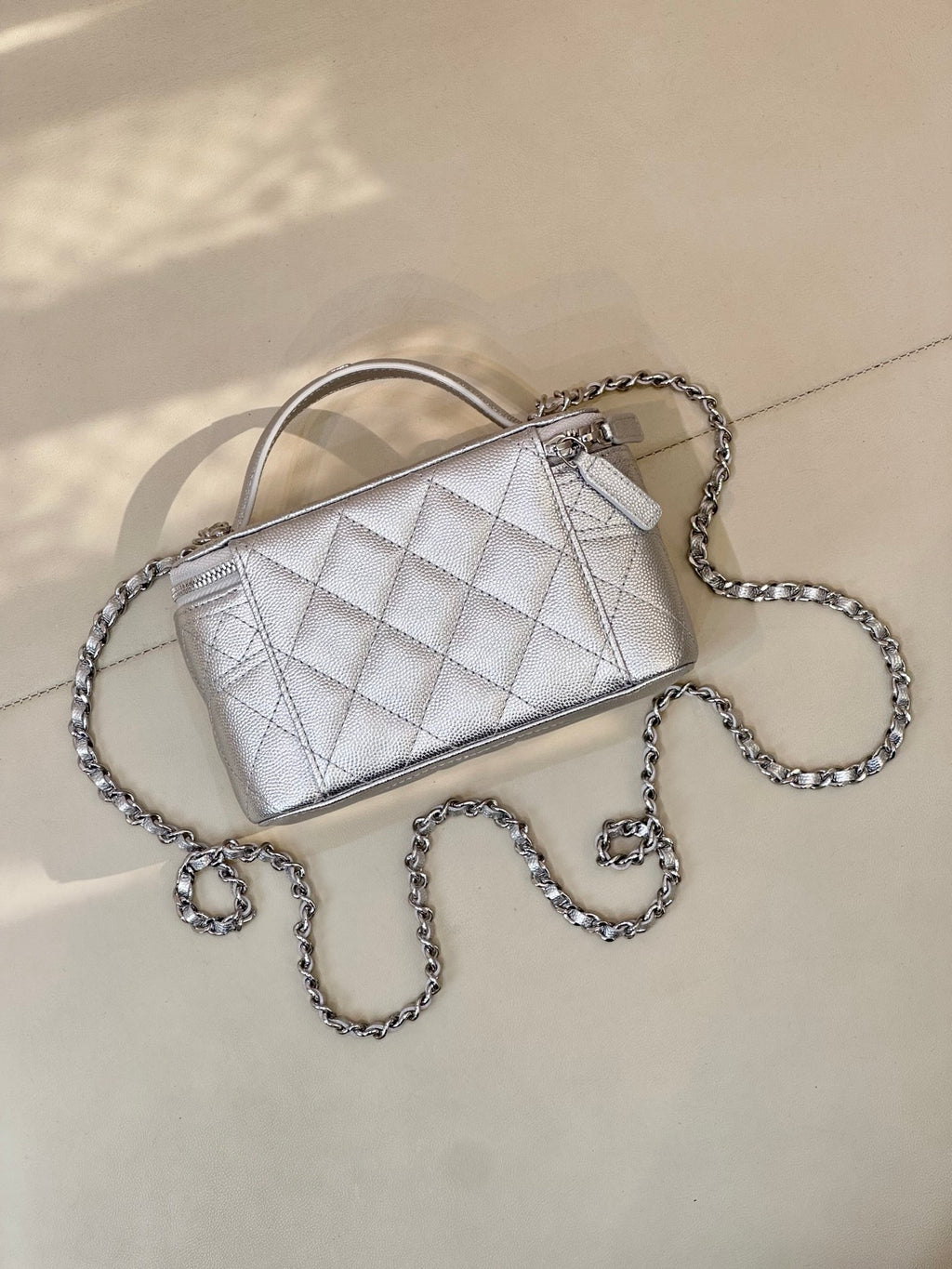 Quilted mini handbag with light silver finish, top handle and silver-tone chain strap, logo