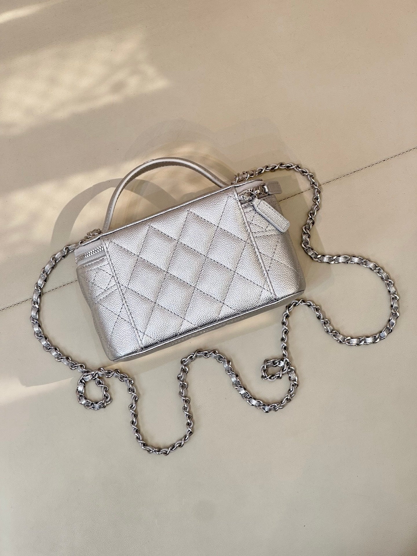 Quilted mini handbag with light silver finish, top handle and silver-tone chain strap, logo