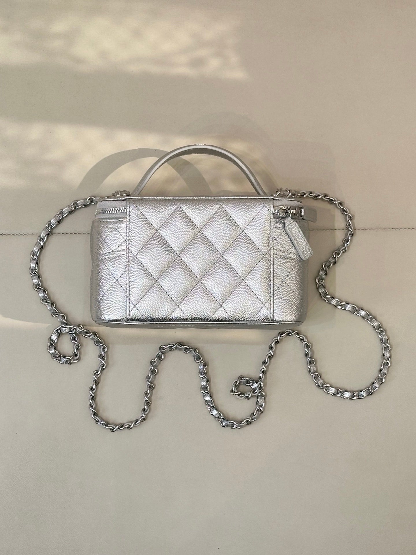 Quilted mini handbag with front flap and silver-tone chain strap, top handle and side hardware