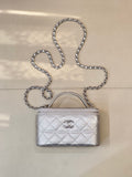 Quilted mini handbag with silver-tone chain strap and top handle, front logo clasp detail
