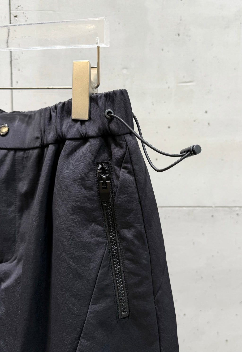 Balenciaga dark pants with drawstring cord detail and front zipper pocket