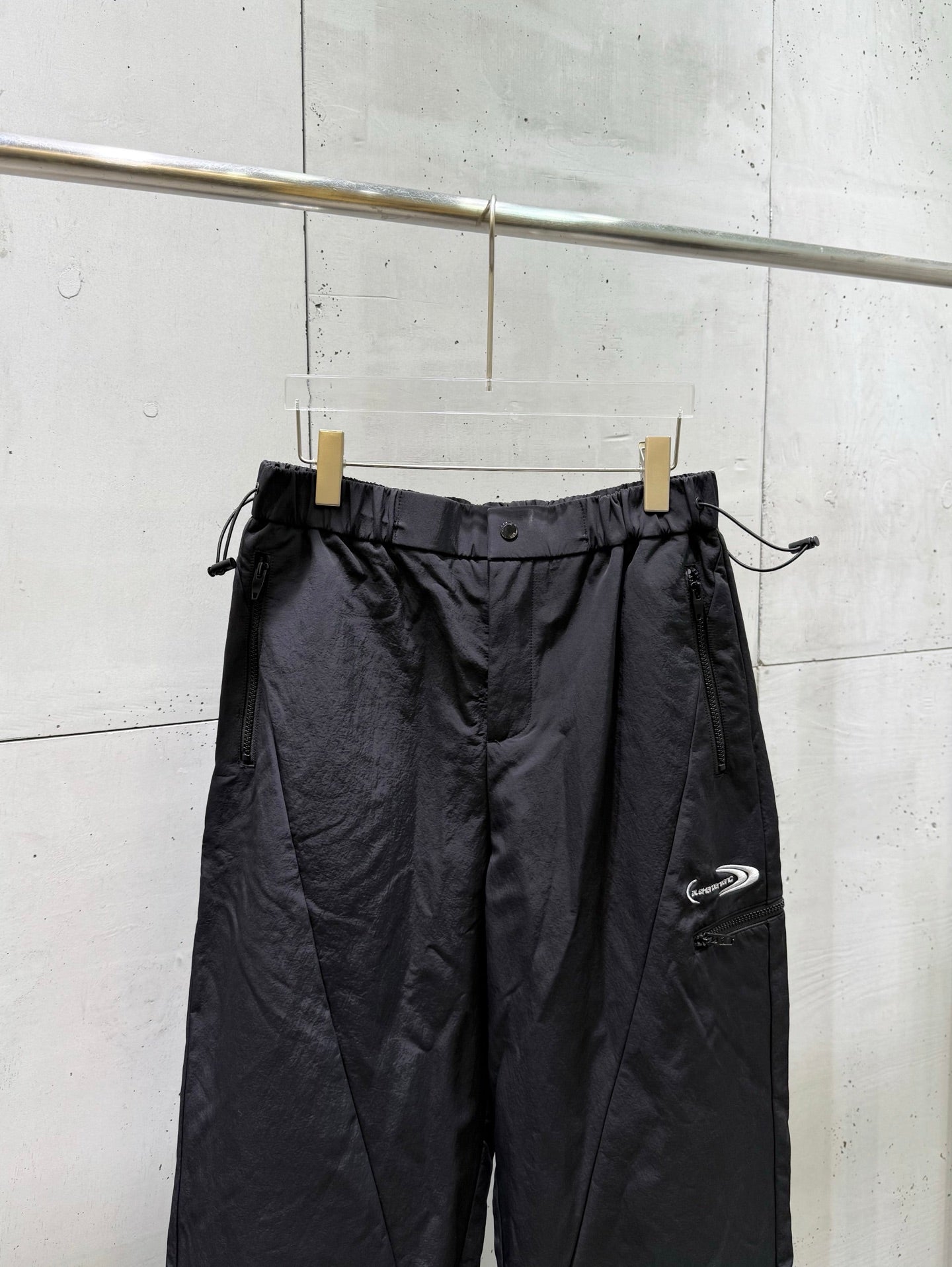 Balenciaga dark wide-leg pants with drawstring waist and side logo patch