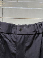 Balenciaga dark pants waistband with metal button at center and elastic gathers
