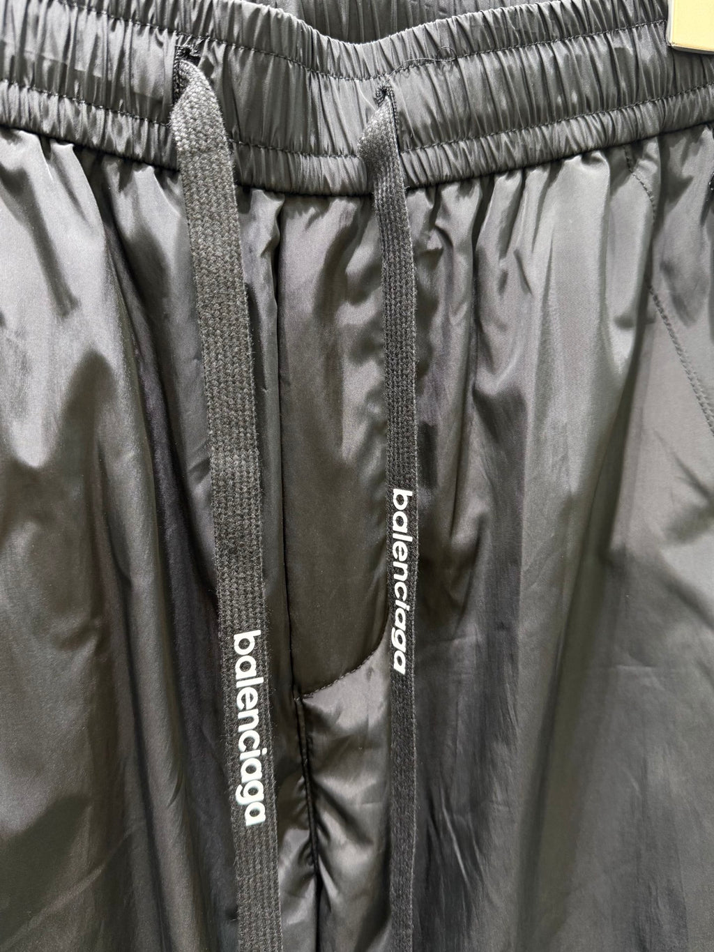 Balenciaga black pants waistband detail with woven drawstring tags and logo label
