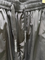 Balenciaga black pants waistband detail with woven drawstring tags and logo label