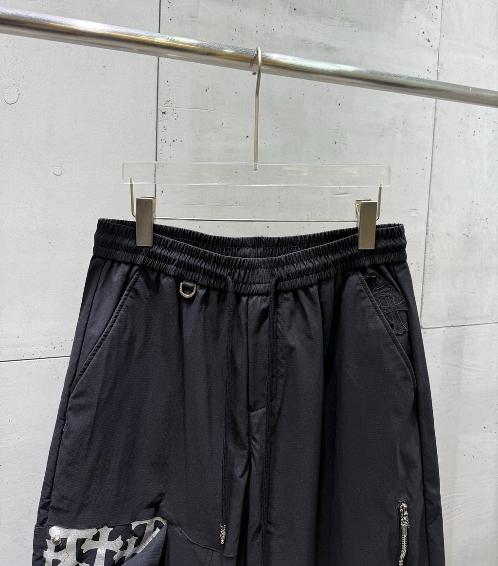 Chrome pants waistband detail with elastic band and drawstring, dark fabric, front seams.