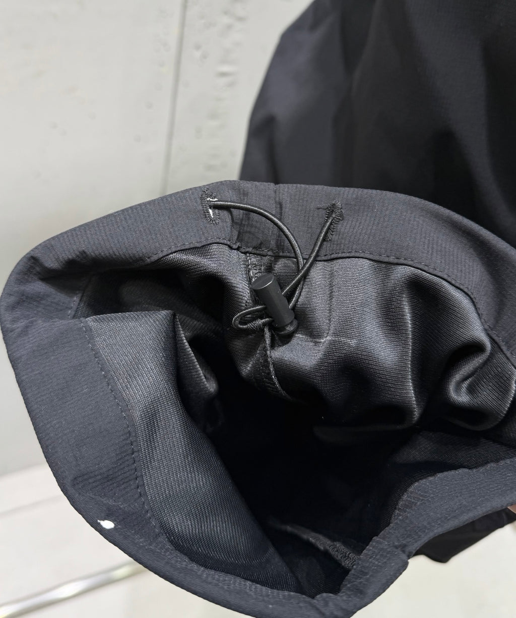 Dark pants interior with drawstring knot and stitched waistband
