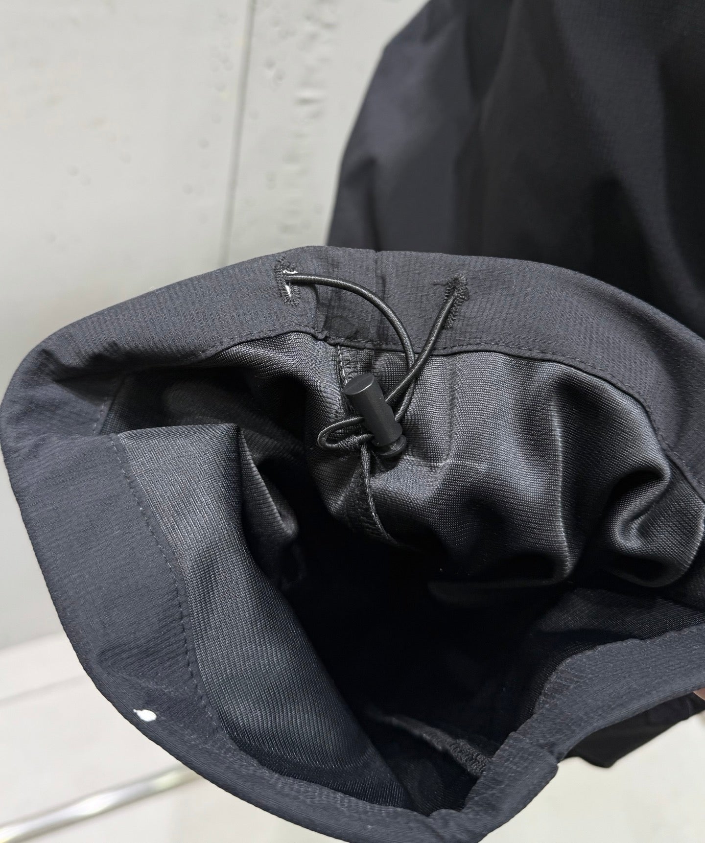 Dark pants interior with drawstring knot and stitched waistband