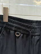 Dark pants elastic waistband with metal ring closure and tie cord