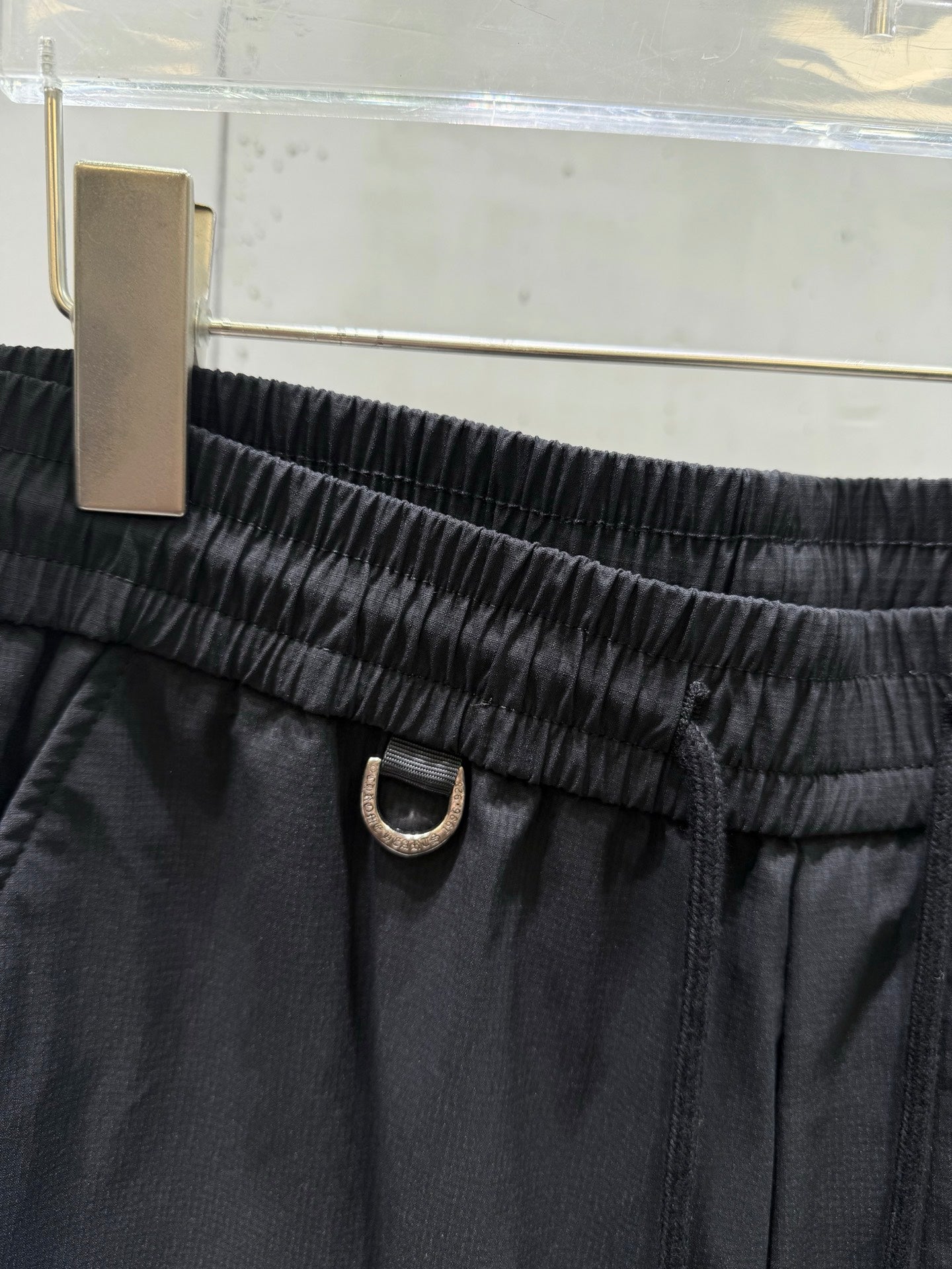 Dark pants elastic waistband with metal ring closure and tie cord