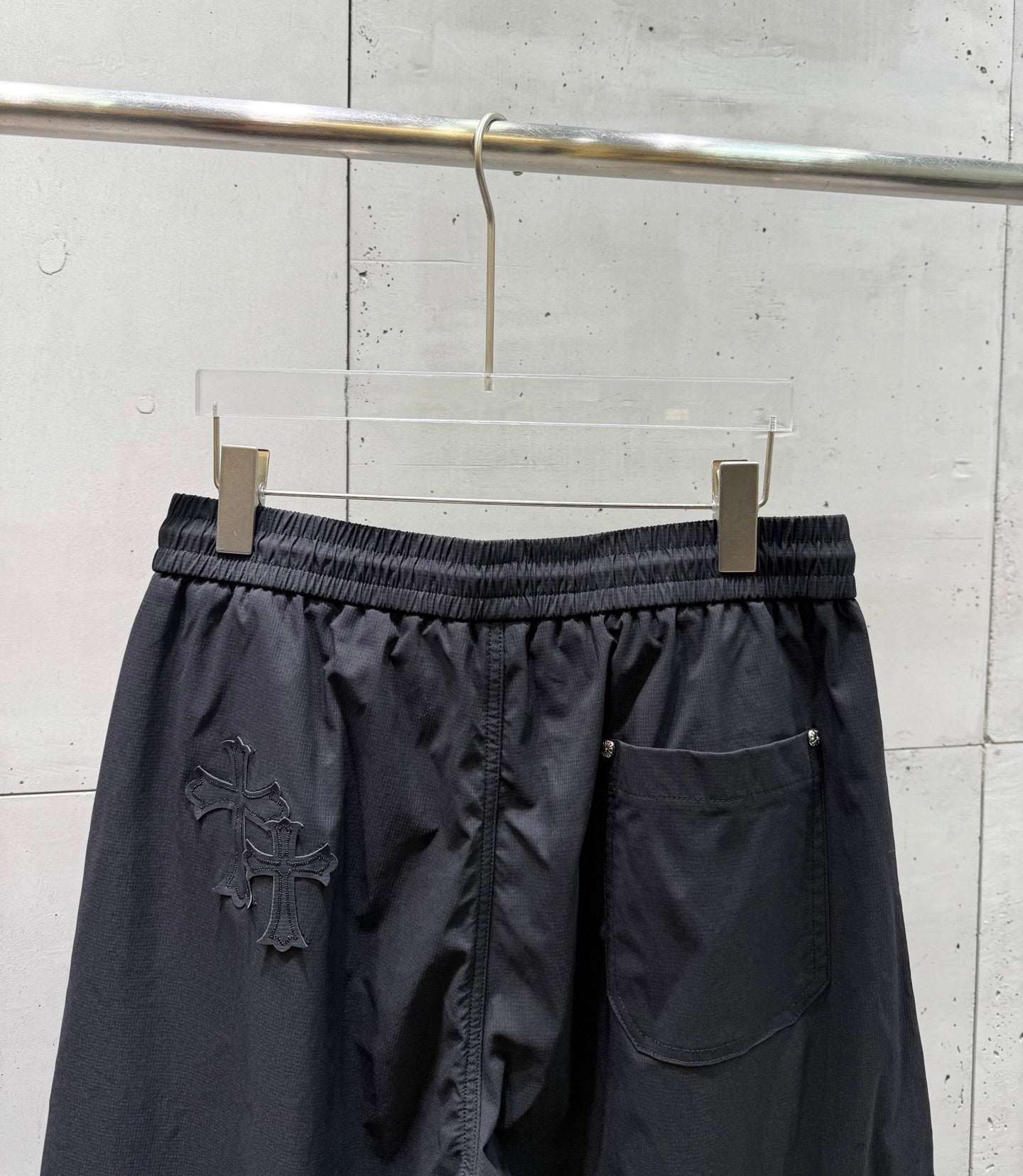 Chrome pants front view with elastic waist, side pocket, and dark wide-leg silhouette.