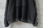 Black hooded sweatshirt with kangaroo pocket and long sleeves.