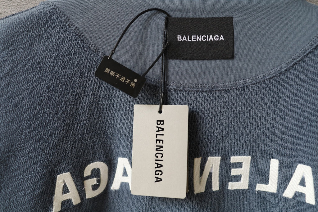 Light blue Balenciaga sweatshirt neckline with hang tags and printed lettering