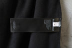 Black fabric pants with printed brand care label sewn inside at waistband
