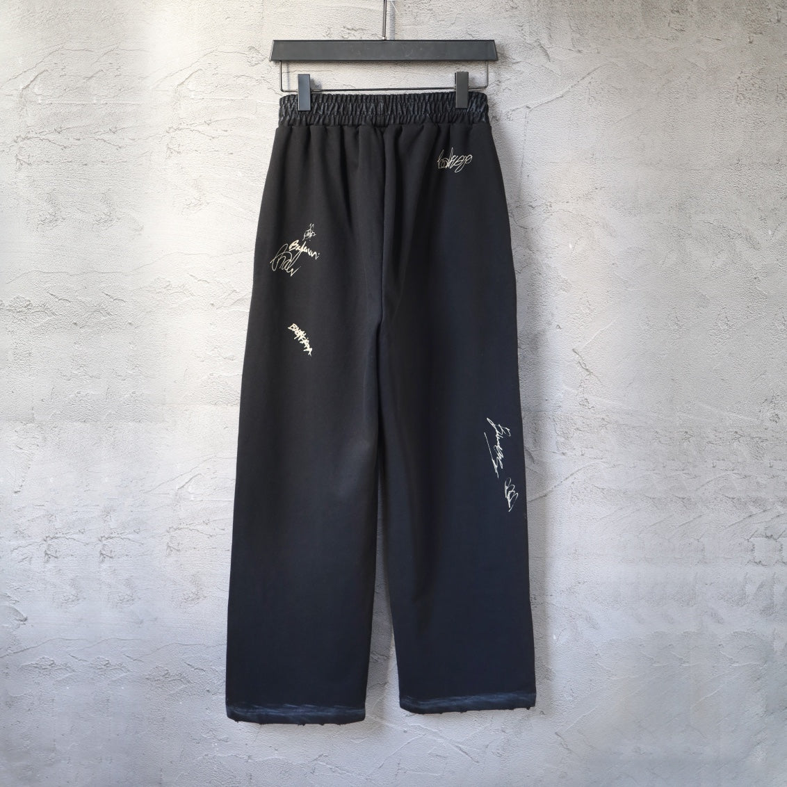 Black wide-leg pants with elastic waistband and scattered light embroidery on front
