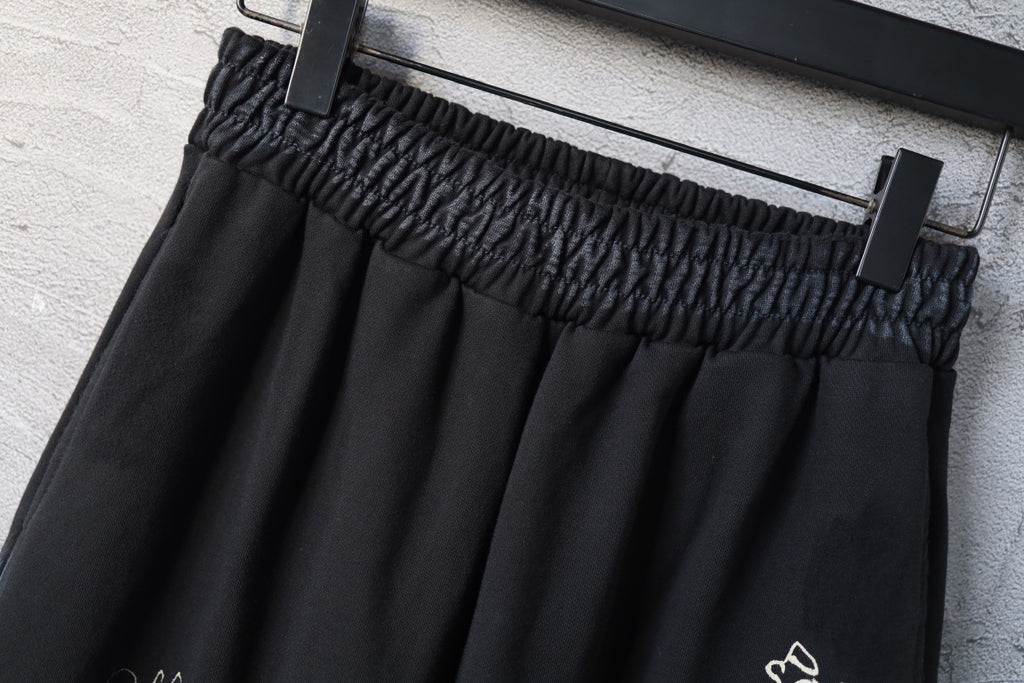 Elastic waistband detail on black wide-leg pants with waistband gathering