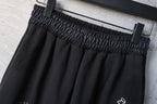 Elastic waistband detail on black wide-leg pants with waistband gathering