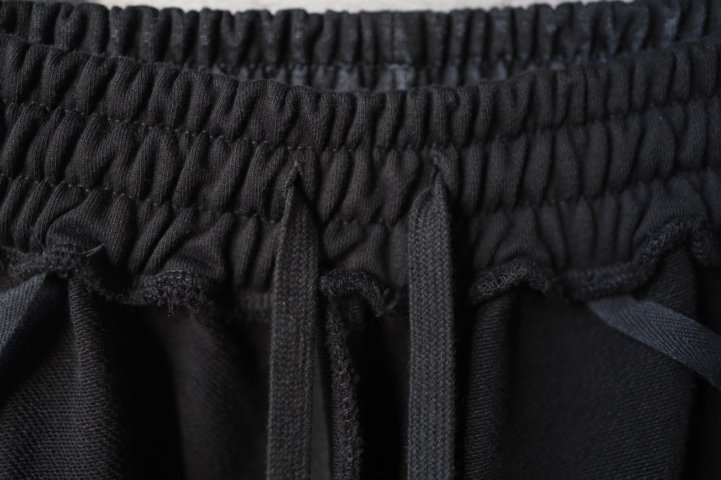 Close-up of black elastic waist seam and gathered fabric at the top