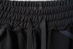 Close-up of black elastic waist seam and gathered fabric at the top