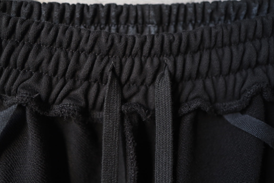 Close-up of black elastic waist seam and gathered fabric at the top