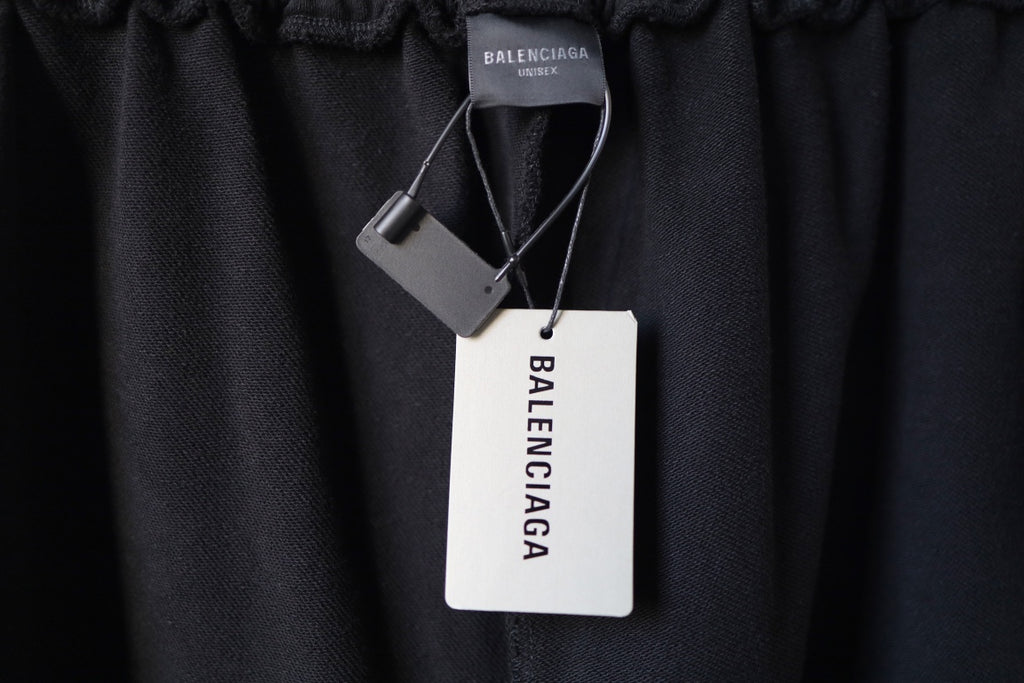 Black pants with hang tags attached near the elastic waistband