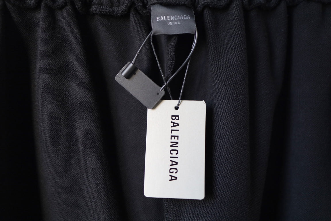 Black pants with hang tags attached near the elastic waistband