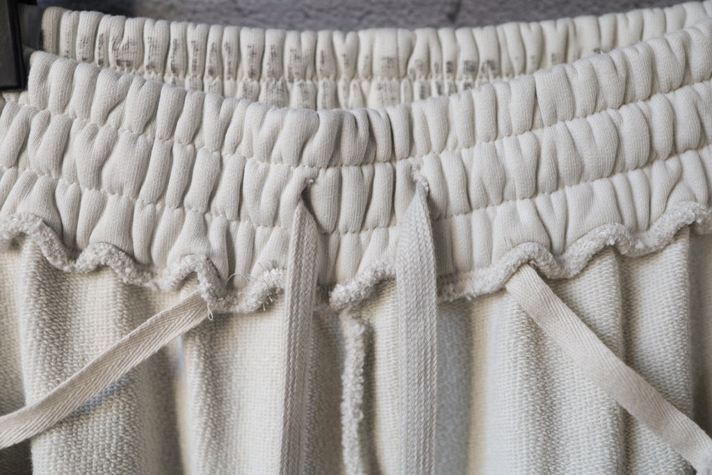 Cream drawstring pants with elastic waistband and bow tie detail