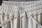 Cream drawstring pants with elastic waistband and bow tie detail