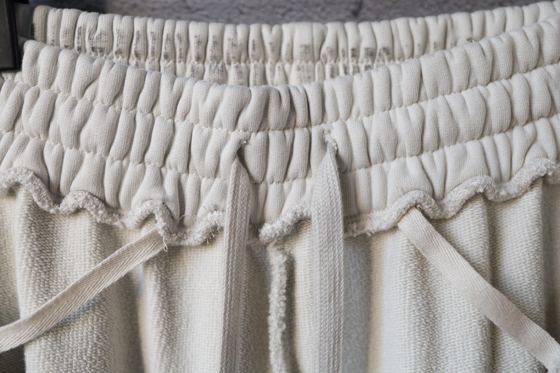 Cream drawstring pants with elastic waistband and bow tie detail