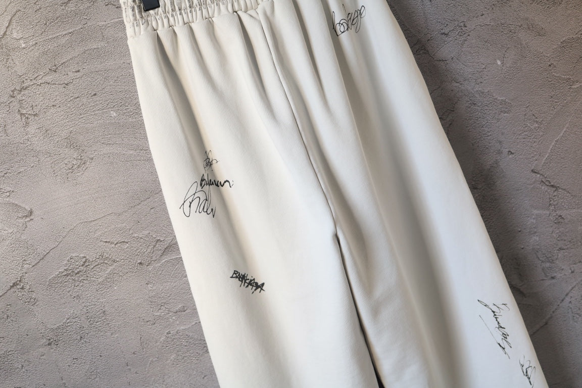 Cream pants with logo print and gathered front fabric detail
