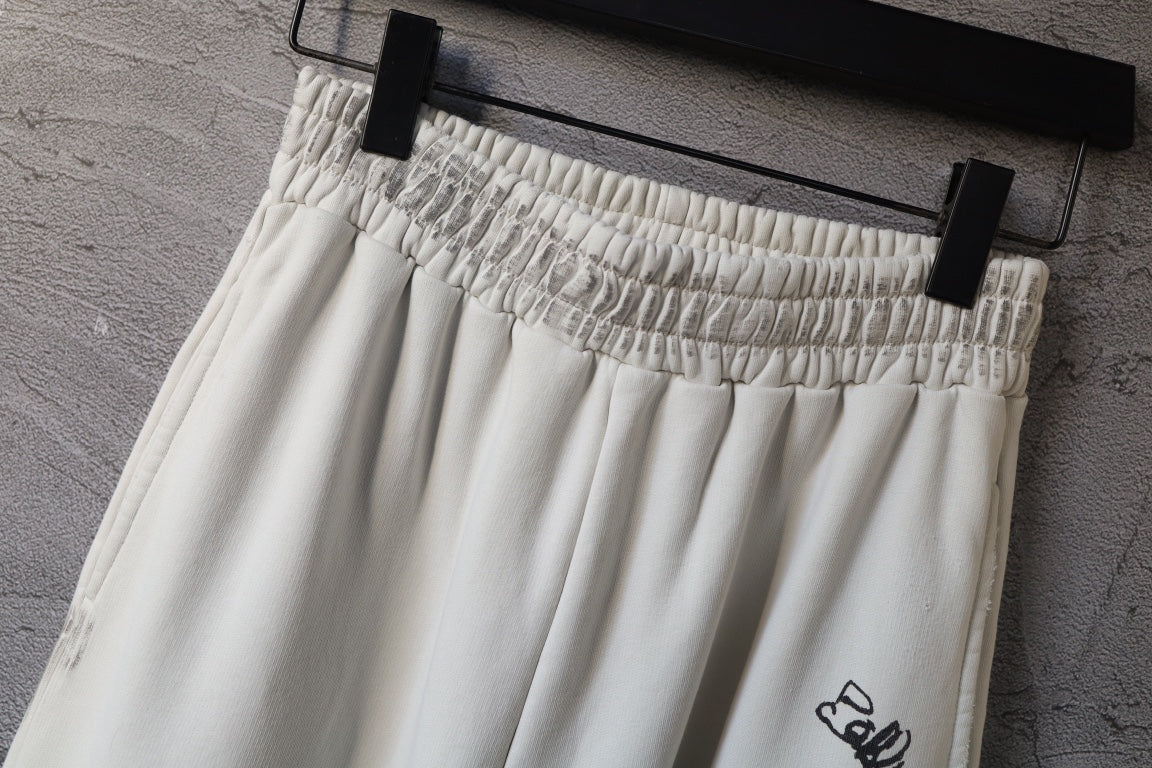 Cream elastic waistband pants with stitched gathers and logo detail