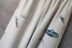 Cream wide-leg pants with printed logos and Balenciaga Paris patch