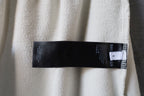 Cream pants showing black size and care label stitched at side seam