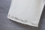 Cream pants hem with visible stitching and frayed edge detail