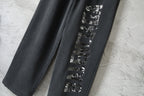 Black Balenciaga pants with vertical silver graphic print on one leg