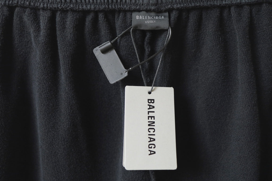 Black Balenciaga pants with hanging tags reading MADE IN CHINA and Balenciaga