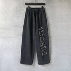 Black wide-leg pants with elastic waistband and long side graphic print