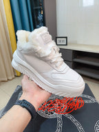 Versace white sneakers with faux-fur collar, held over box with logo print