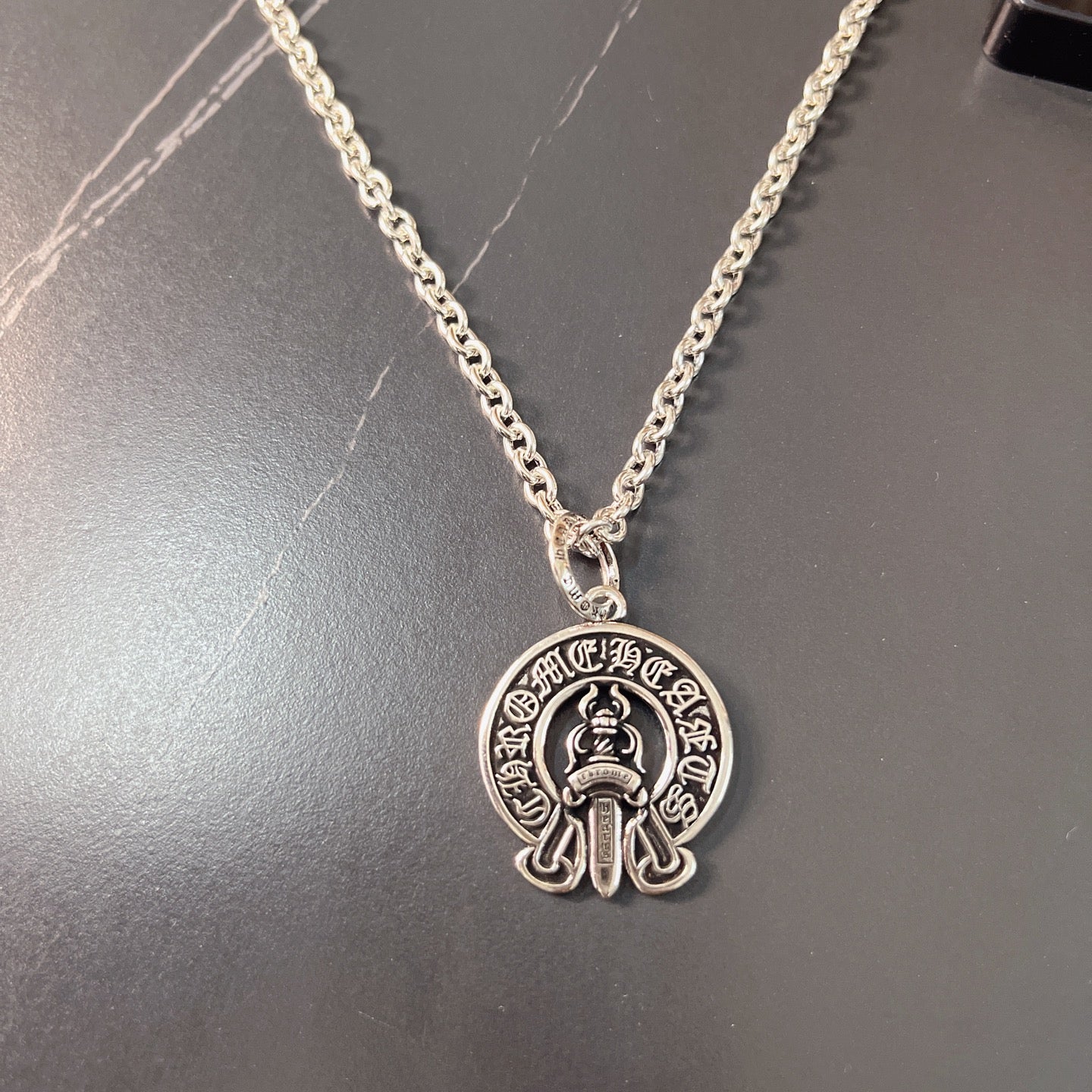 Silver chain necklace with round emblem pendant