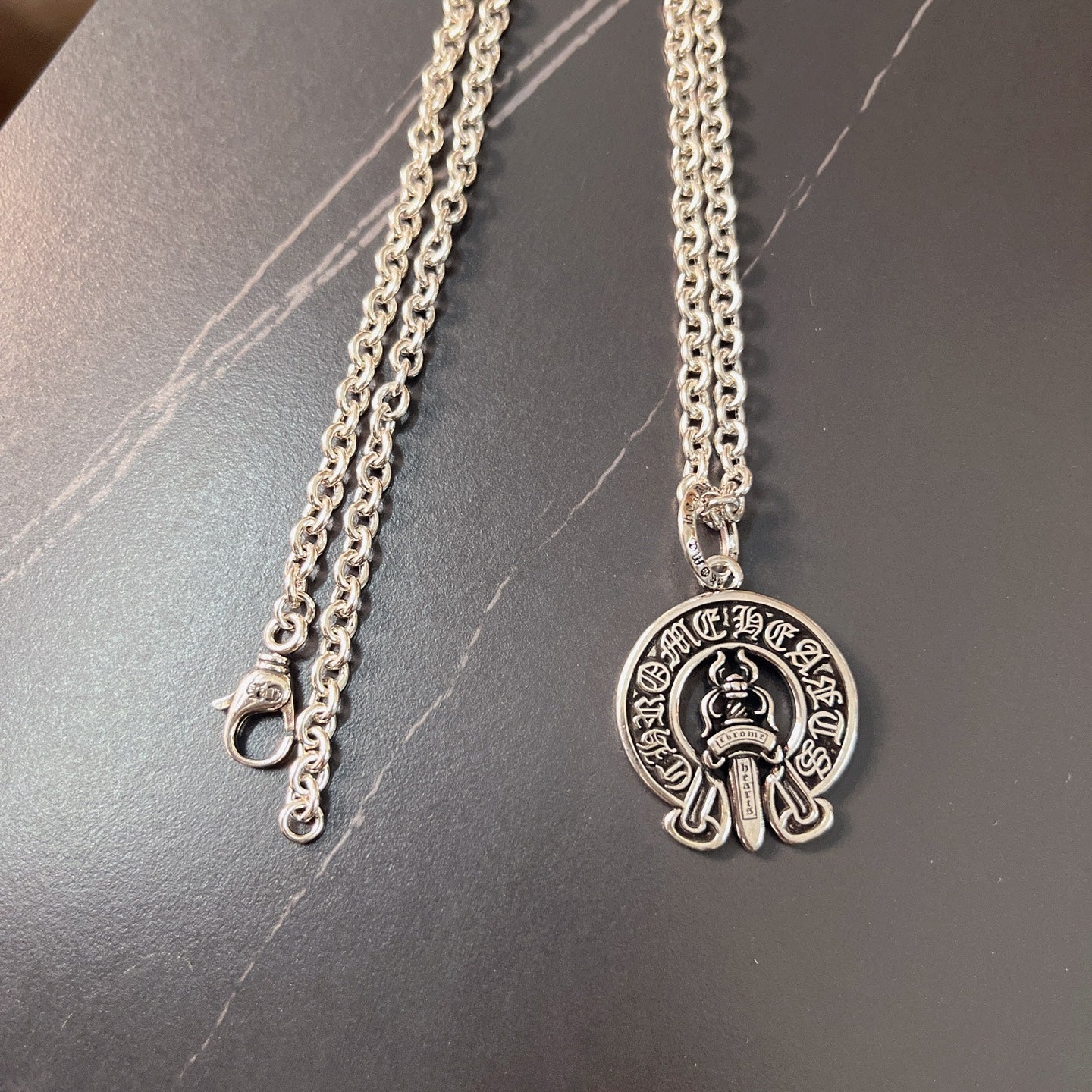 Silver chain necklace with round emblem pendant