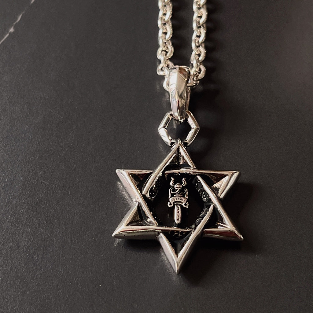 Silver chain necklace with star pendant and black center detail