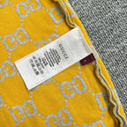 Yellow knit sweater label area with GG logo pattern and stitched neckline