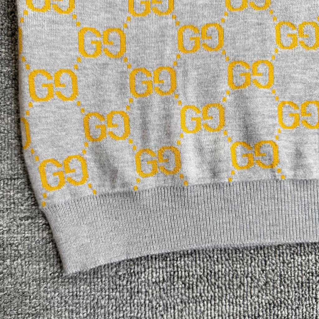 Close-up of sweater hem with ribbed trim and yellow GG logo pattern